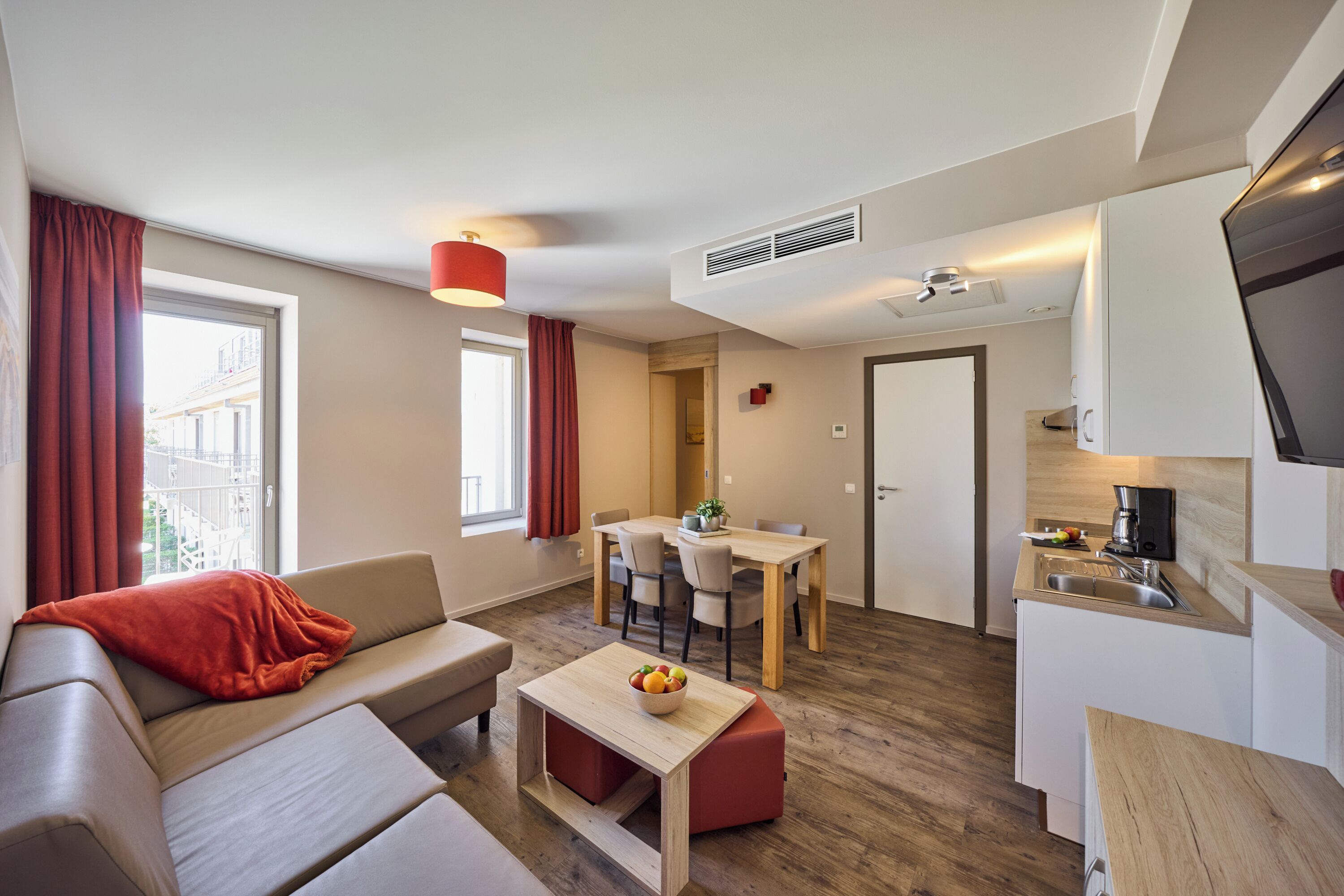 Un espace de vie moderne comprenant un canapé, une table à manger et un coin cuisine.