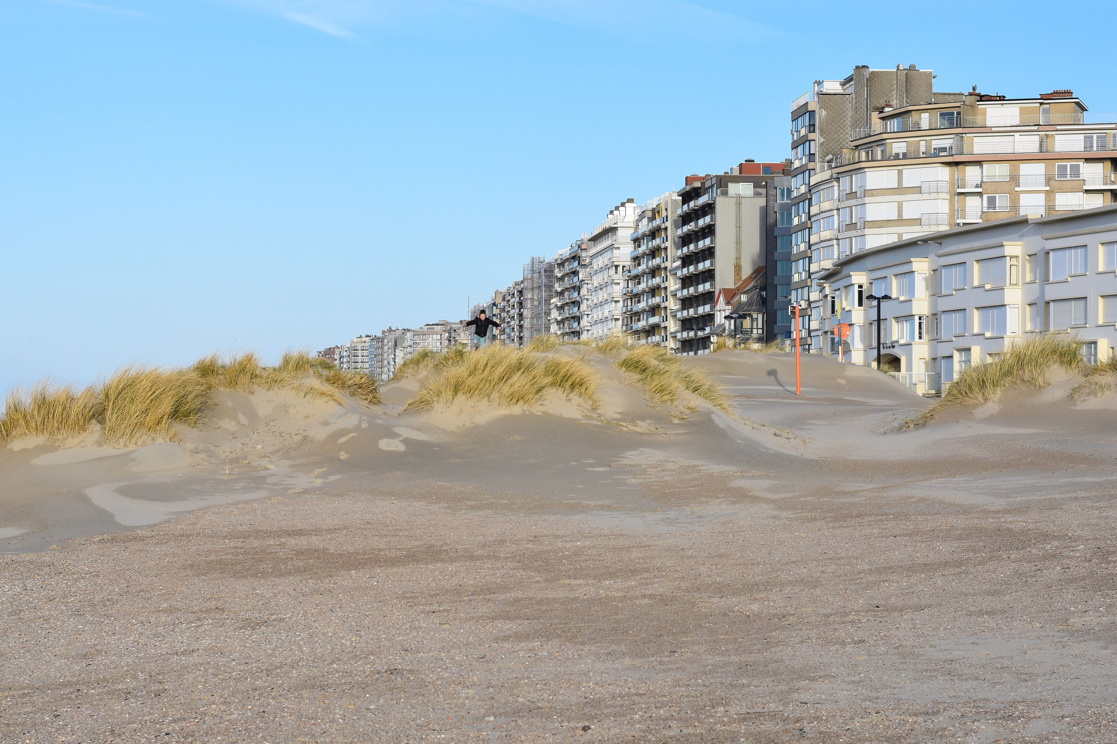 Una zona costera con edificios y dunas de arena.