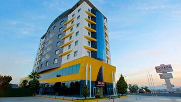 RAMADA hotel features a modern architectural design with large windows and a prominent entrance.