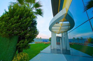 Una piscina al aire libre, sombrillas, sillones reclinables de piscina