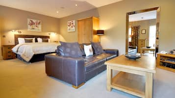 Une chambre à coucher avec un lit, un canapé, une table et un miroir.