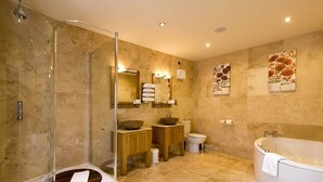 Un baño moderno con ducha de vidrio, una bañera independiente y un tocador con un espejo grande.