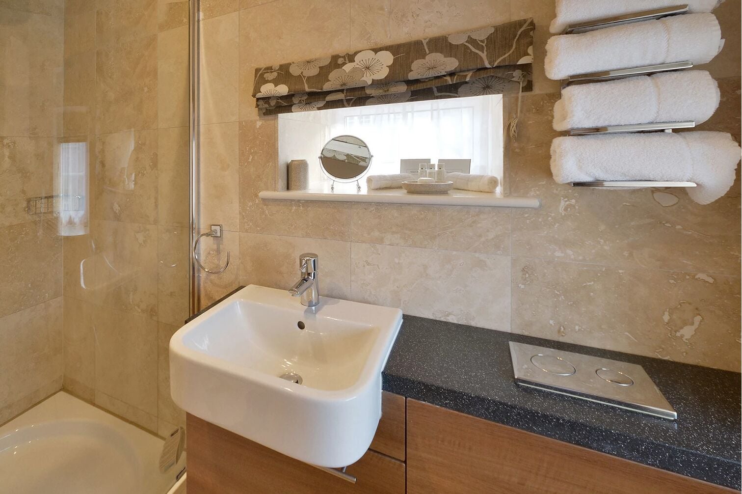 A bathroom with a sink, mirror, and towel rack.