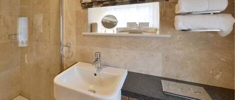 A bathroom with a sink, mirror, and towel rack.