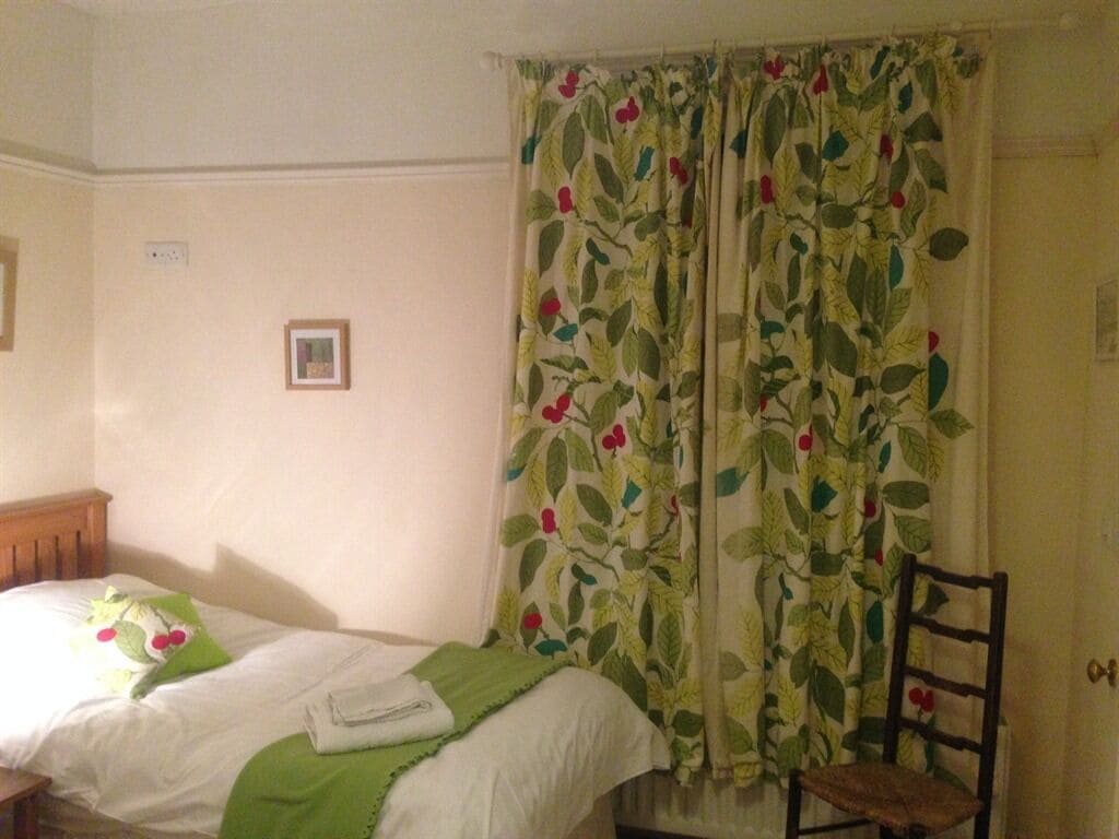 Una camera da letto con un letto, una sedia e una porta.