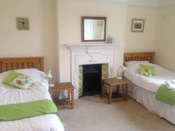 A room with two beds, a fireplace, and a small table. - Old Church House B&B (Newport)