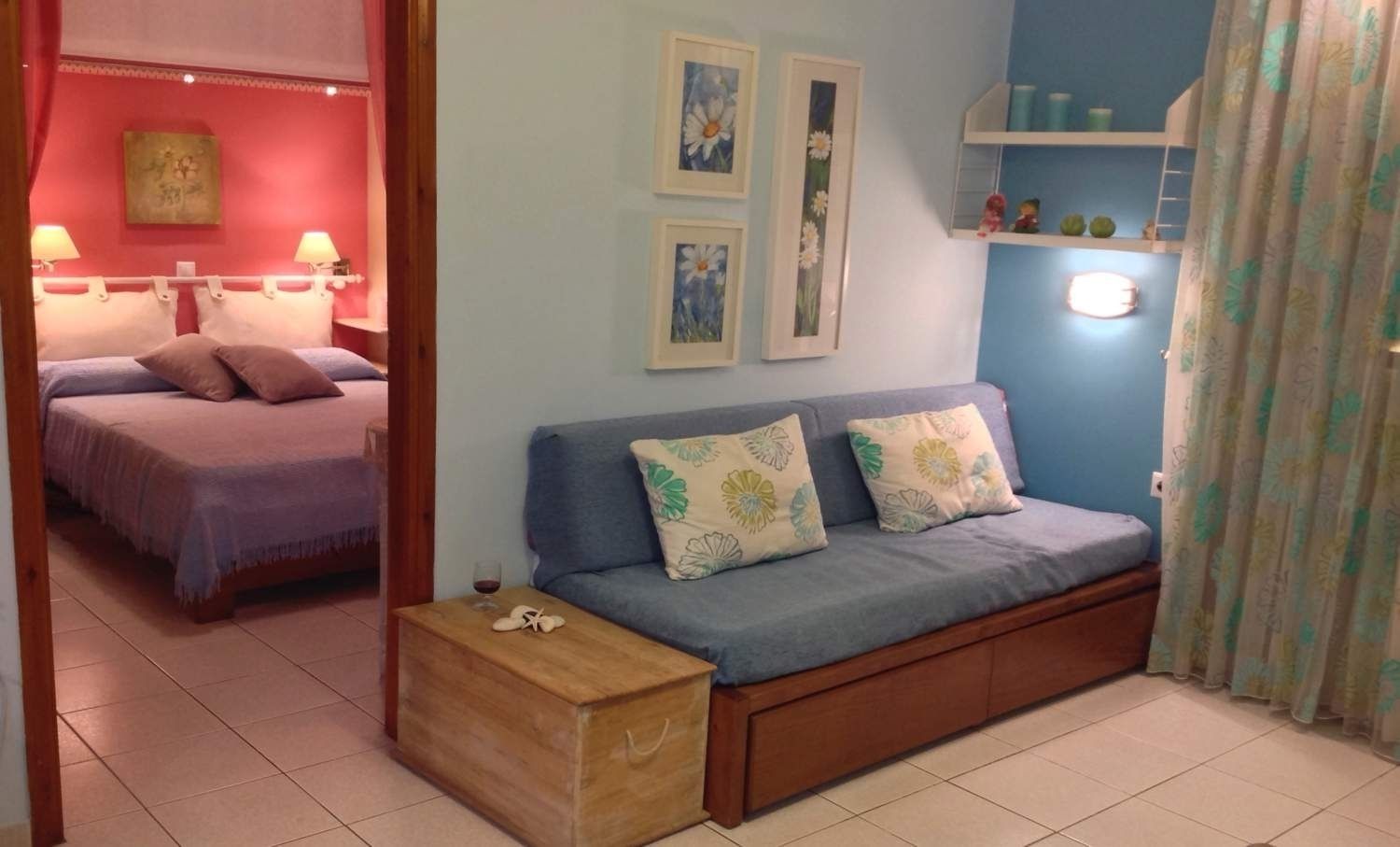 A cozy bedroom with a bed, a sofa, and a nightstand.