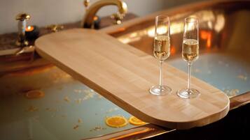 A wooden tray with two glasses of champagne on a reflective surface with orange peel designs.