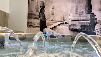 Bathroom features a central water feature and a large, mounted photograph of a historical scene.