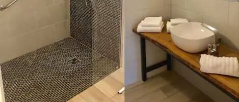 Een badkamer met douchecabine, wastafel en spiegel.