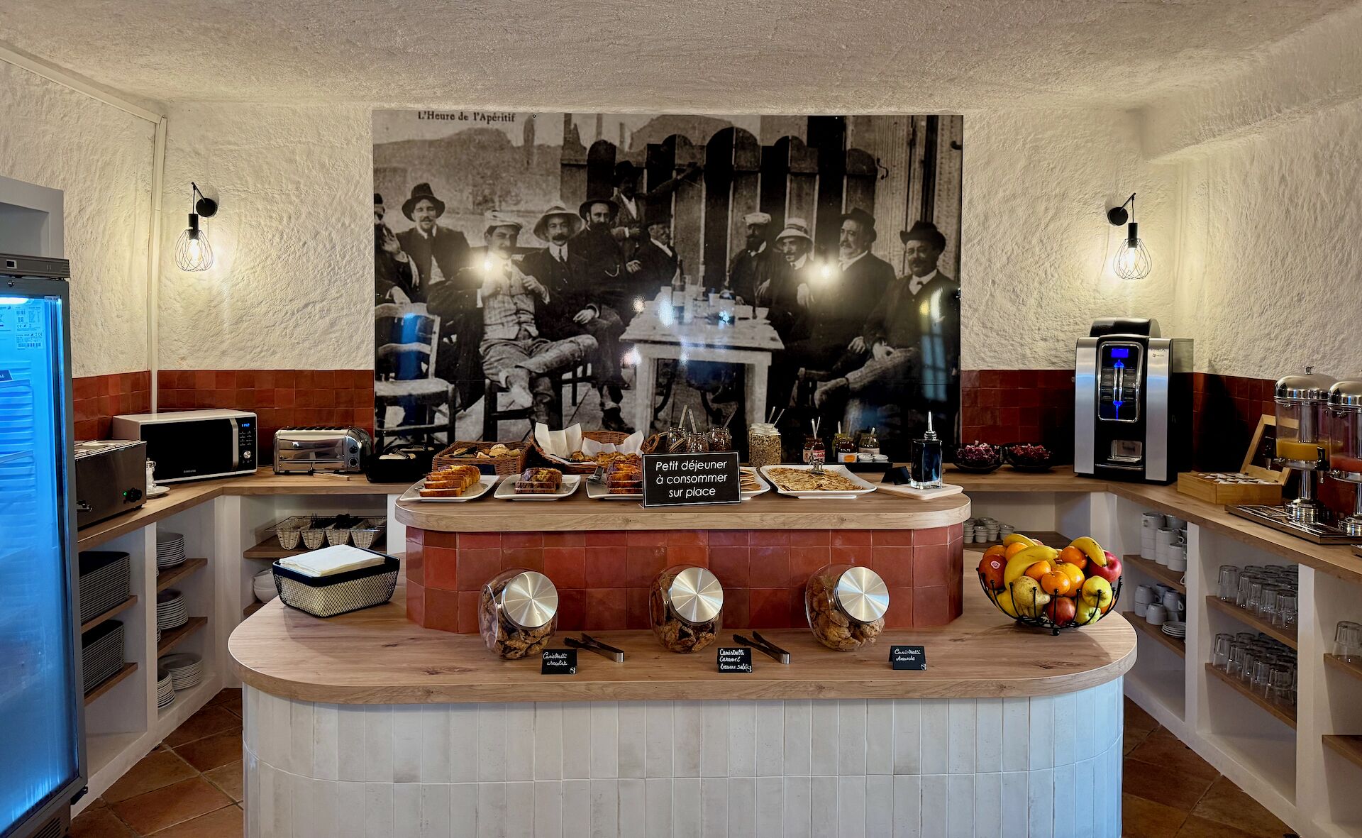 A breakfast bar with a vintage photo backdrop, a coffee machine, and various food items.