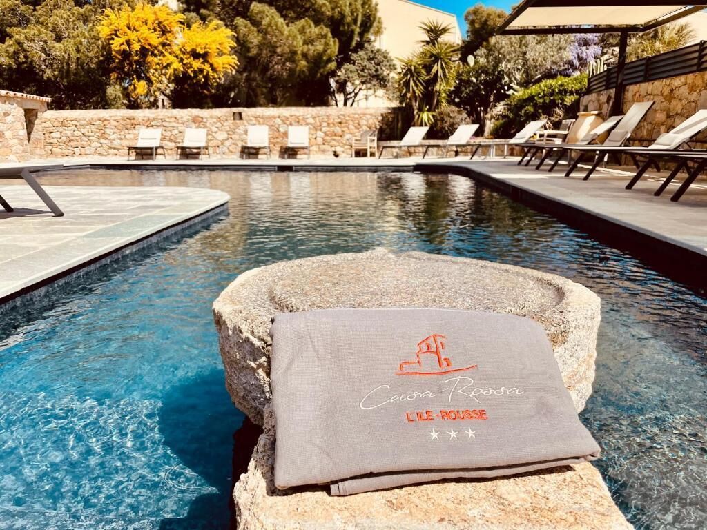 A pool area with lounge chairs and a towel with text.
