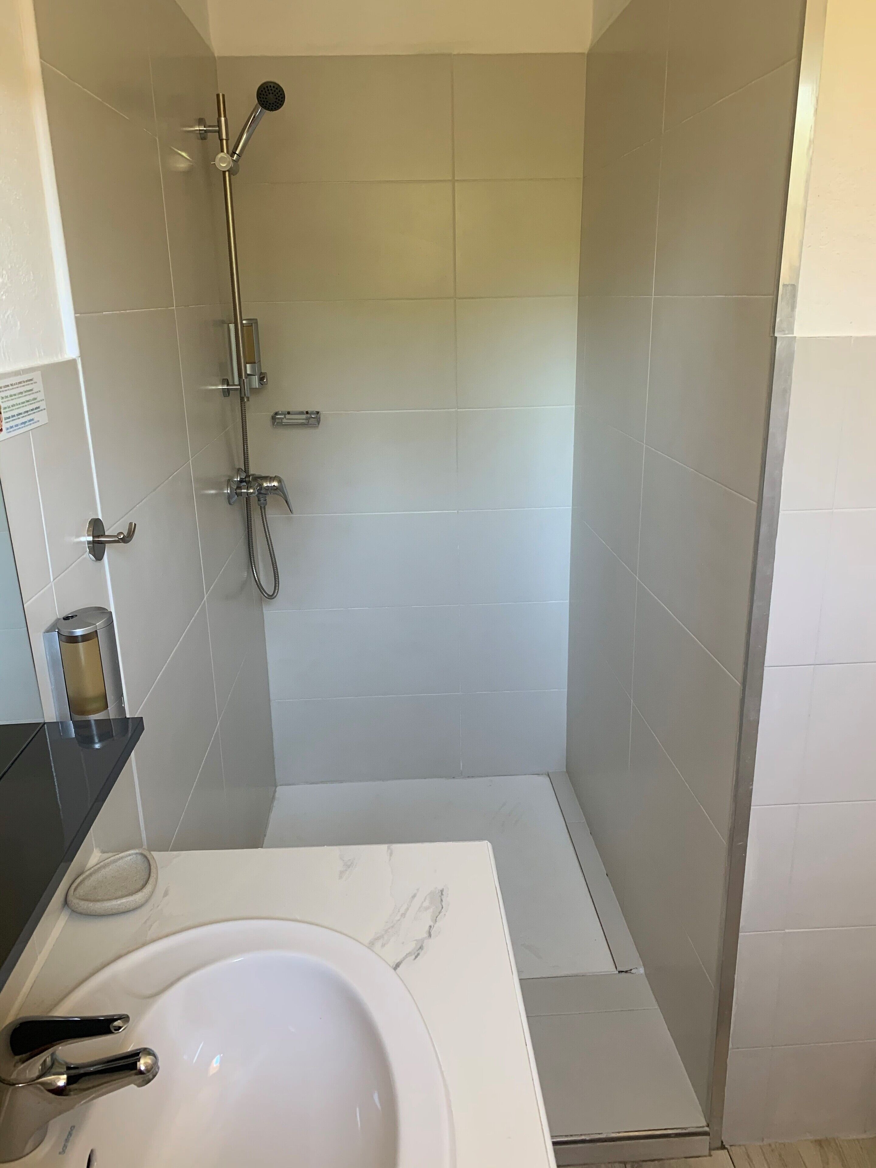 Un baño con ducha, lavabo e inodoro.
