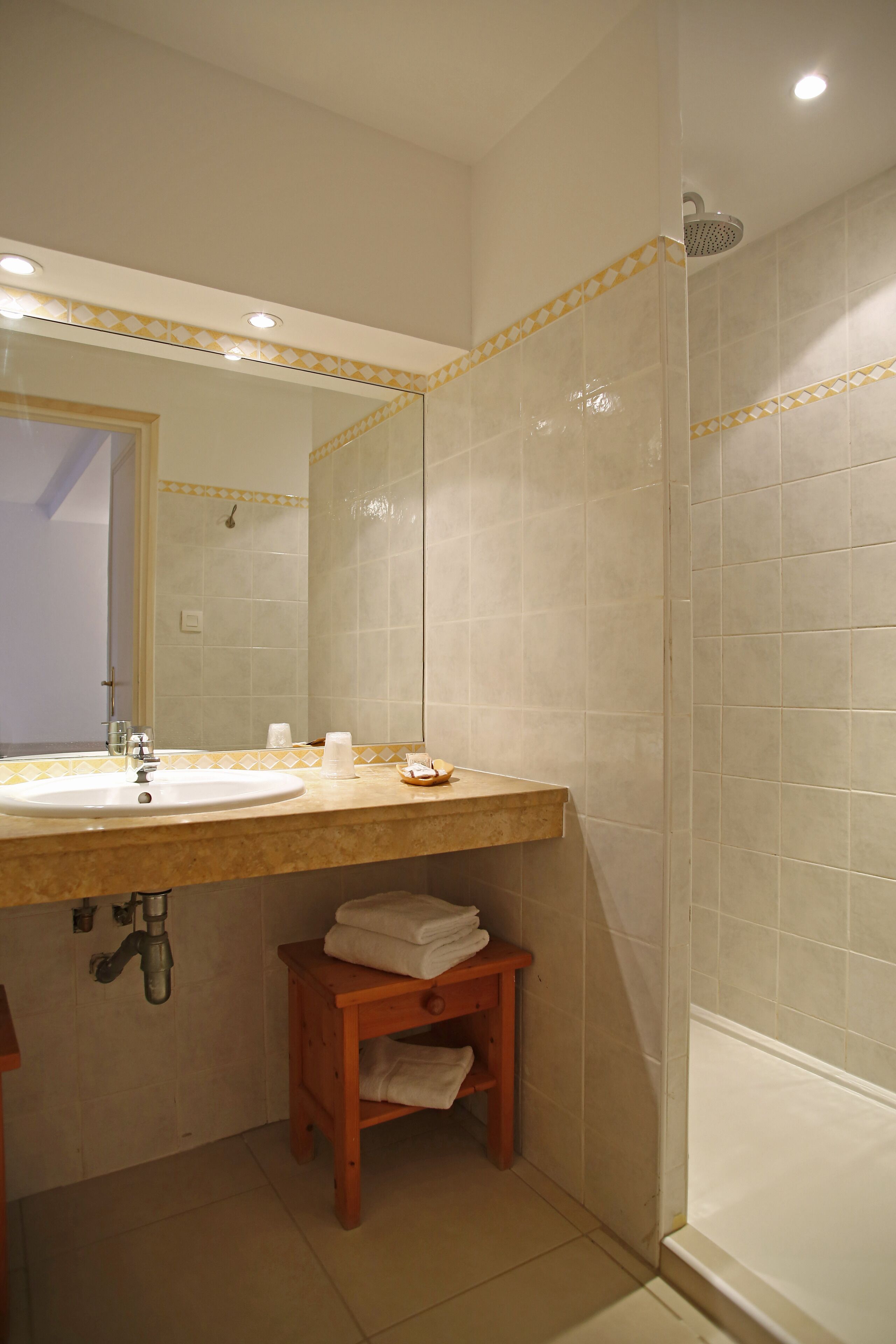 Un baño con lavamanos, espejo y ducha.