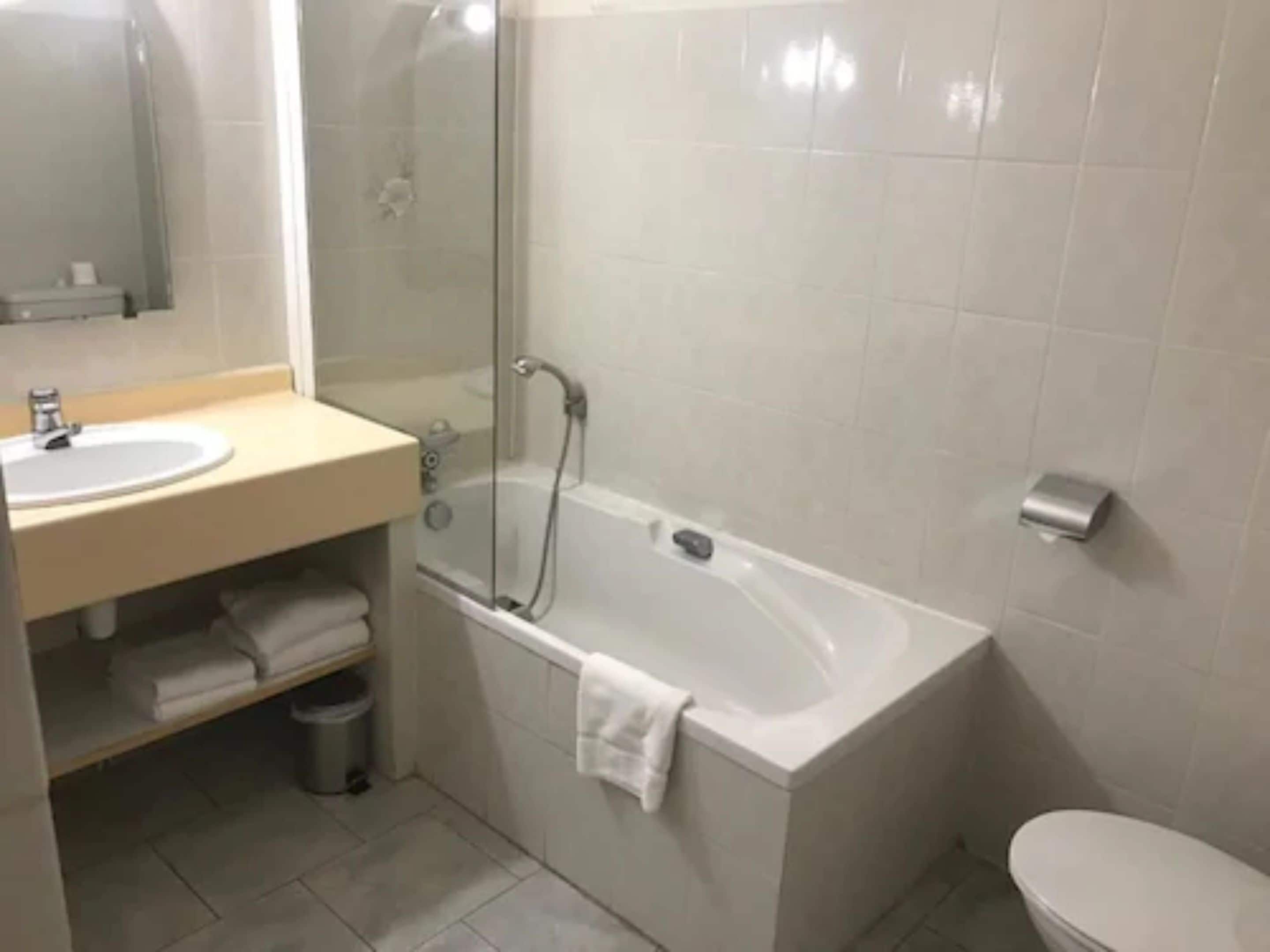 A bathroom with a bathtub, a sink, and a toilet.