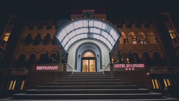 Ein Hotel mit einem prunkvollen Bogen und Treppen, die zu ihm hinaufführen.