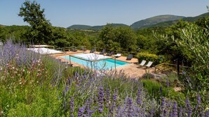 Un espace piscine doté de chaises longues et offrant une vue sur le paysage environnant.