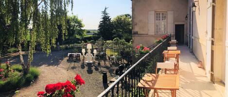 Une terrasse avec des sièges extérieurs et une vue sur le jardin.