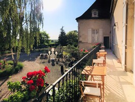 Una terraza con mobiliario exterior y vista a un jardín.