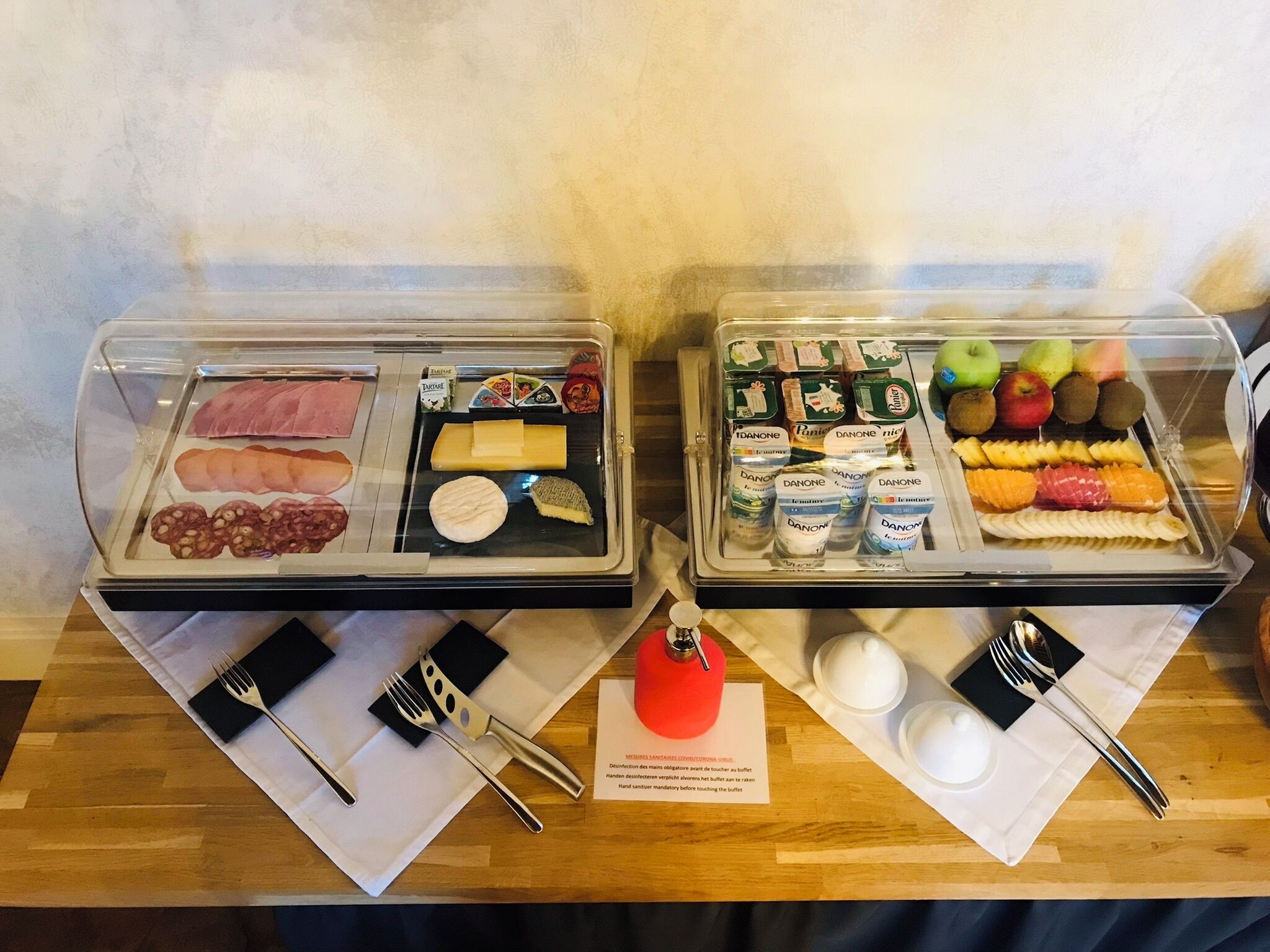 Un buffet proposant une variété de plats, notamment des viandes, des fromages et des fruits.