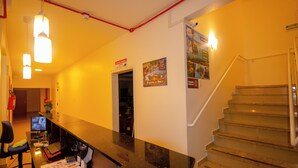 A reception area with a desk, computer, and a staircase. - Hotel Penha (Penha)