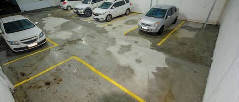 A parking garage with several cars parked in designated spaces.