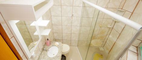 A modern bathroom with a glass-enclosed shower, a marble sink, and a toilet.