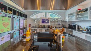A modern kitchen with a Bosch induction cooktop, stainless steel appliances, and a variety of utensils and condiments on the counter. - GRAND your home with common kitchens with self check-in (Engelberg)