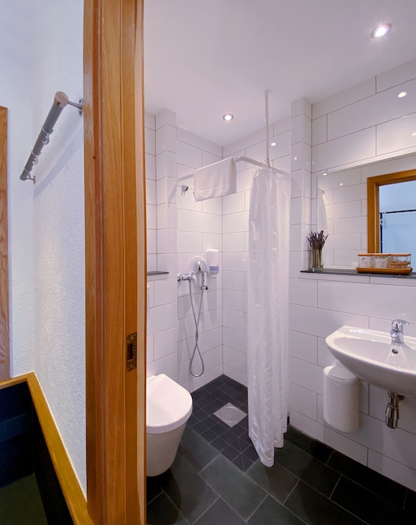 Un baño moderno con ducha, inodoro y lavamanos.