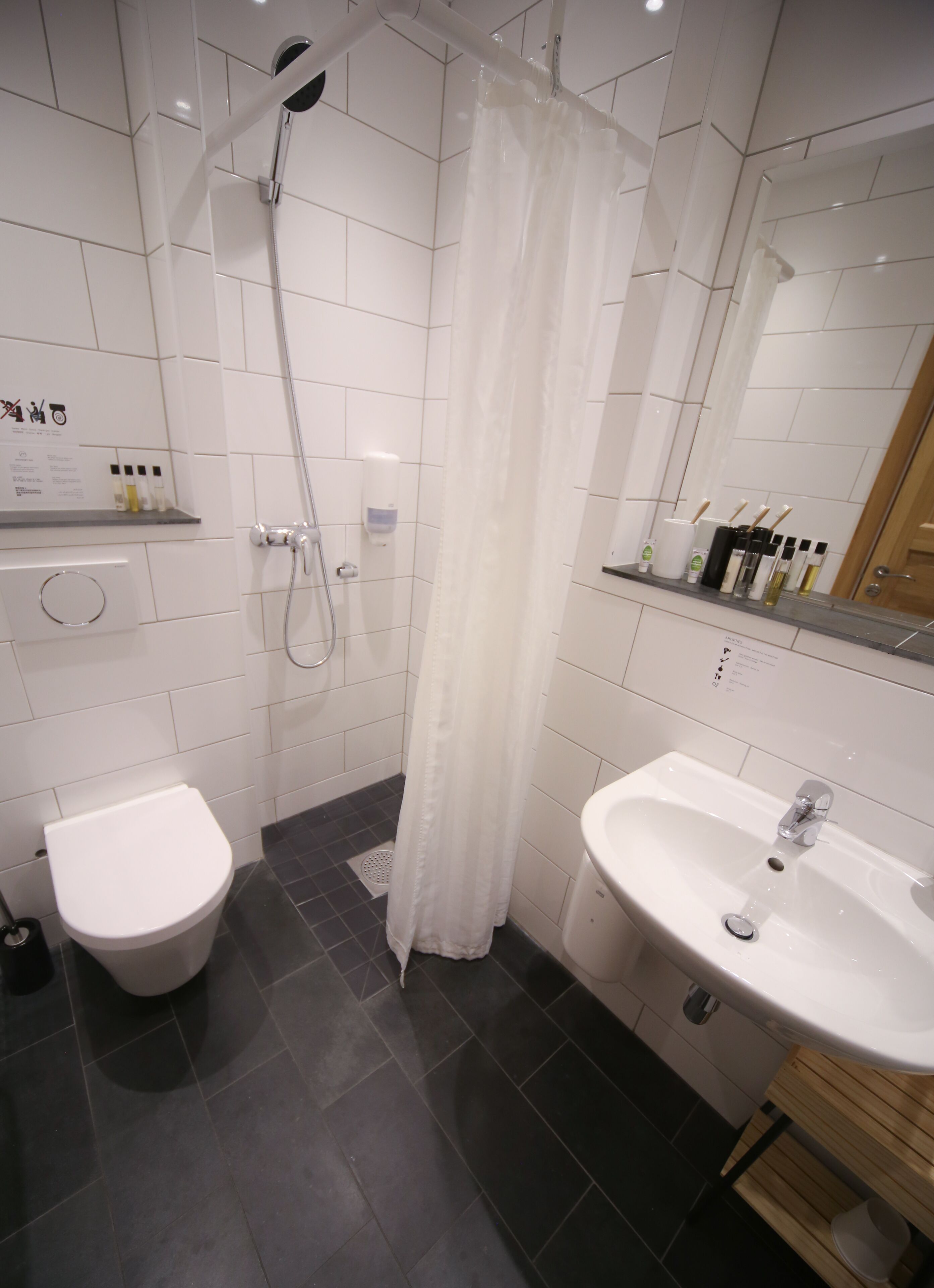 Une salle de bain moderne équipée d’une douche, de toilettes et d’un lavabo.