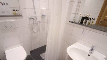 Une salle de bain moderne équipée d’une douche, de toilettes et d’un lavabo.