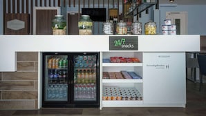 A 24/7 snack bar with a refrigerator stocked with beverages and a freezer. - Hampton by Hilton Amsterdam Centre East (Amsterdam)