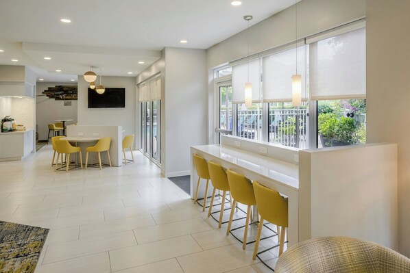 Una cocina moderna con comedor, ventanas amplias y vistas al exterior.