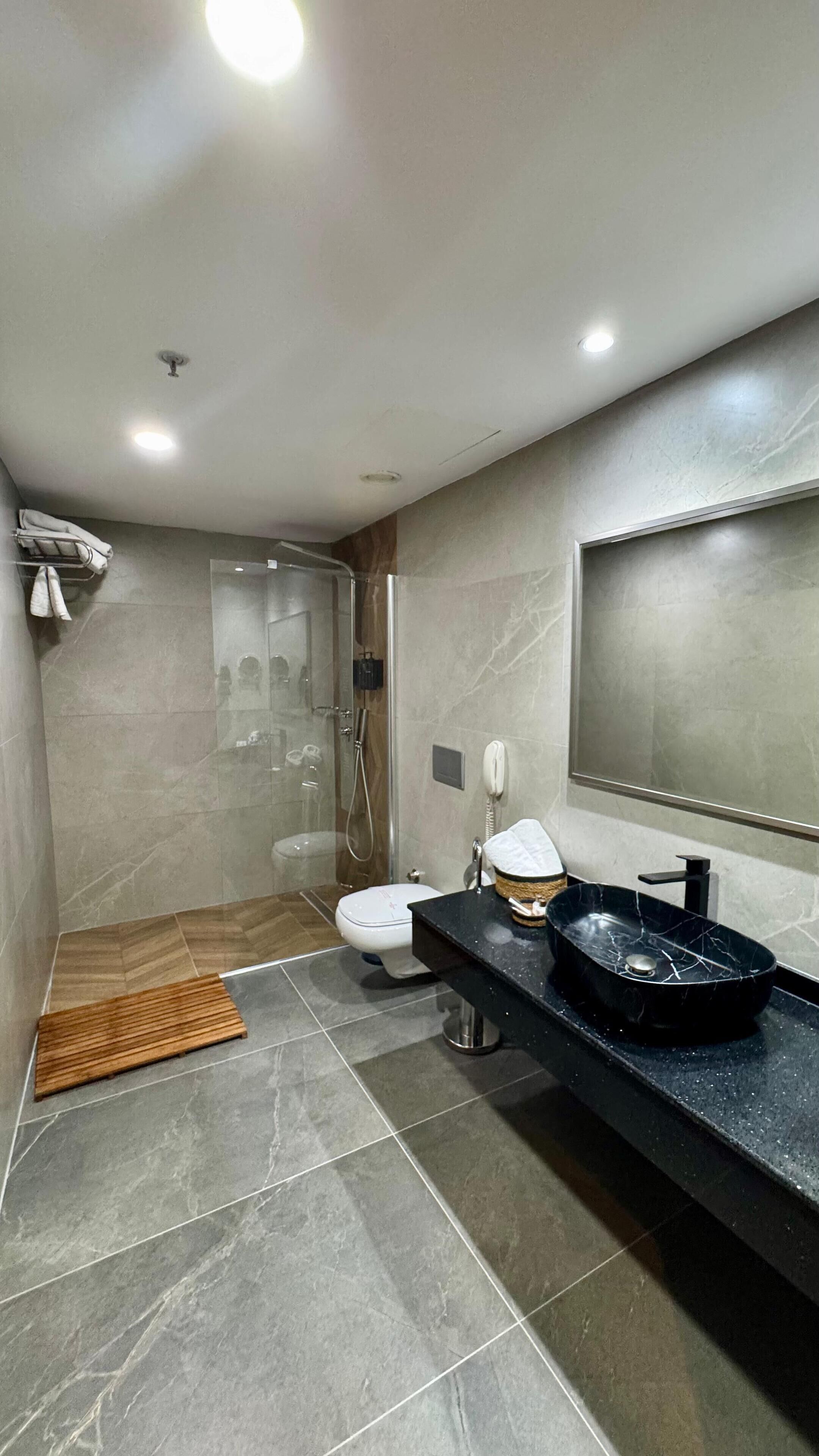 deluxe studio suite | bathroom | designer toiletries, hair dryer, slippers, towels