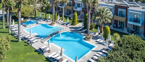 Una piscina al aire libre de temporada, sombrillas