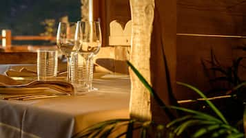 A table set with clear glasses, a folded napkin, and a wooden chair.