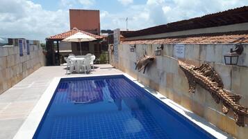 Una piscina al aire libre, sombrillas, tumbonas