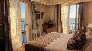 Suite junior, vistas al mar | Ropa de cama de alta calidad, minibar, caja fuerte y escritorio