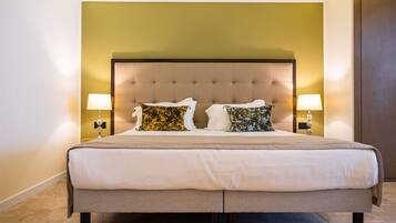 A large bed with a tufted headboard, two bedside lamps, and decorative pillows.