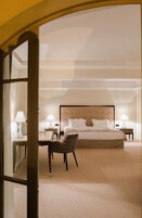Un dormitorio de hotel con una cama grande, dos mesitas de noche con lámparas, una silla y suelo alfombrado.
