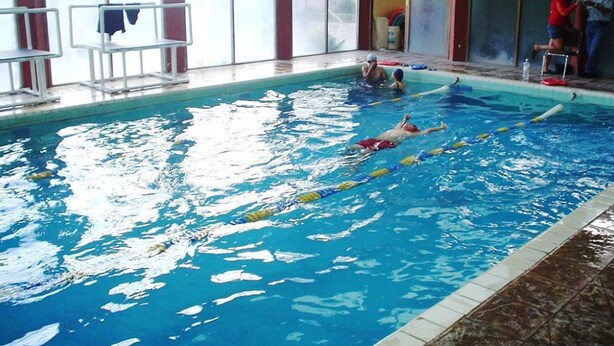 An indoor swimming pool with clear lanes, a diving board, and a tiled floor. - Motel La Fortuna (Fresnillo)