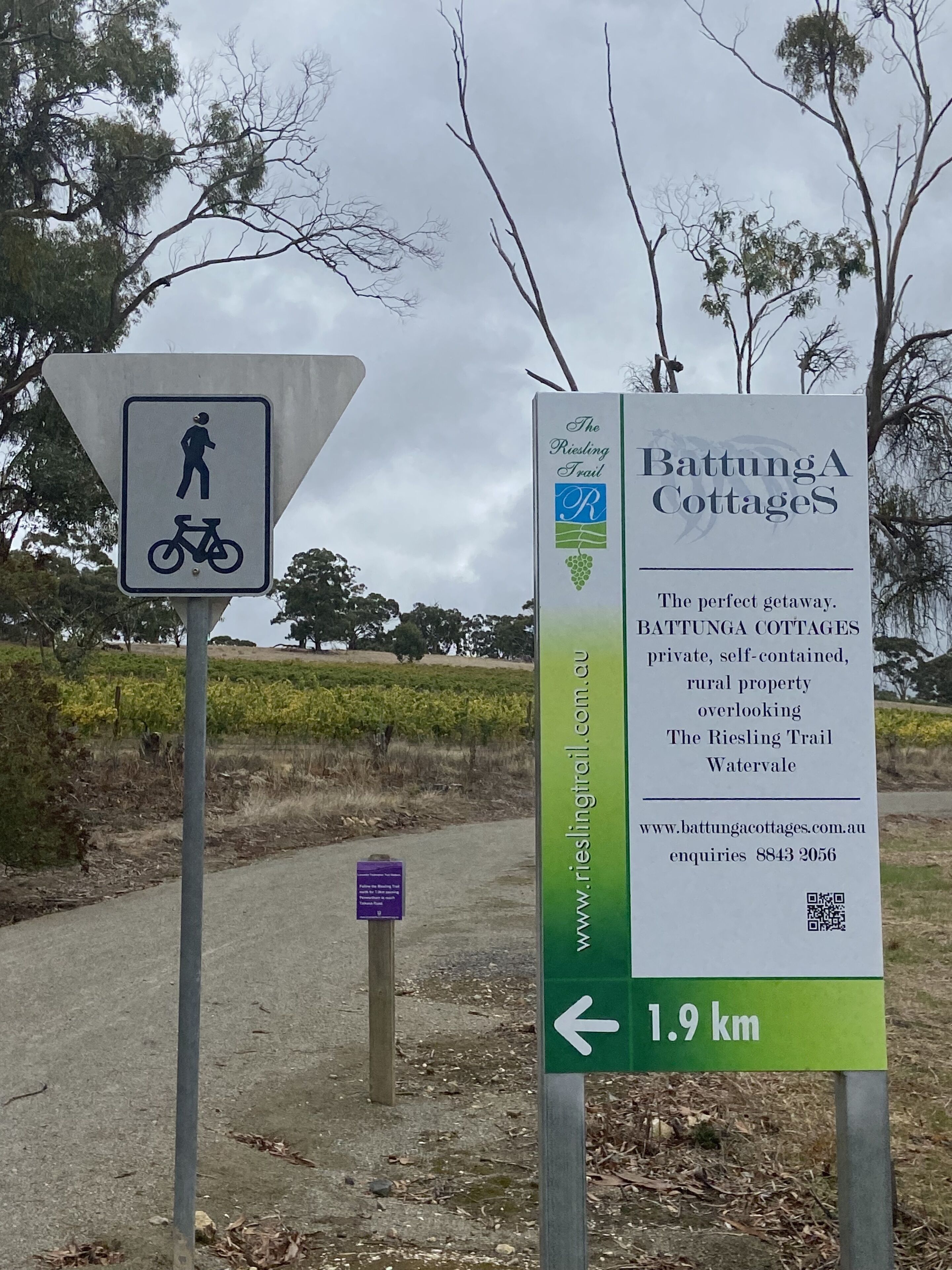 Une pancarte indiquant les « Battunga Cottages » et faisant la publicité d’une propriété rurale isolée, dotée de toutes commodités et offrant une vue sur le sentier de randonnée de Riesling.