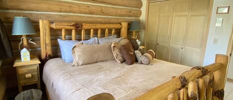 Un letto con struttura in legno, una testiera, un comodino con una lampada e un'armadio in legno.