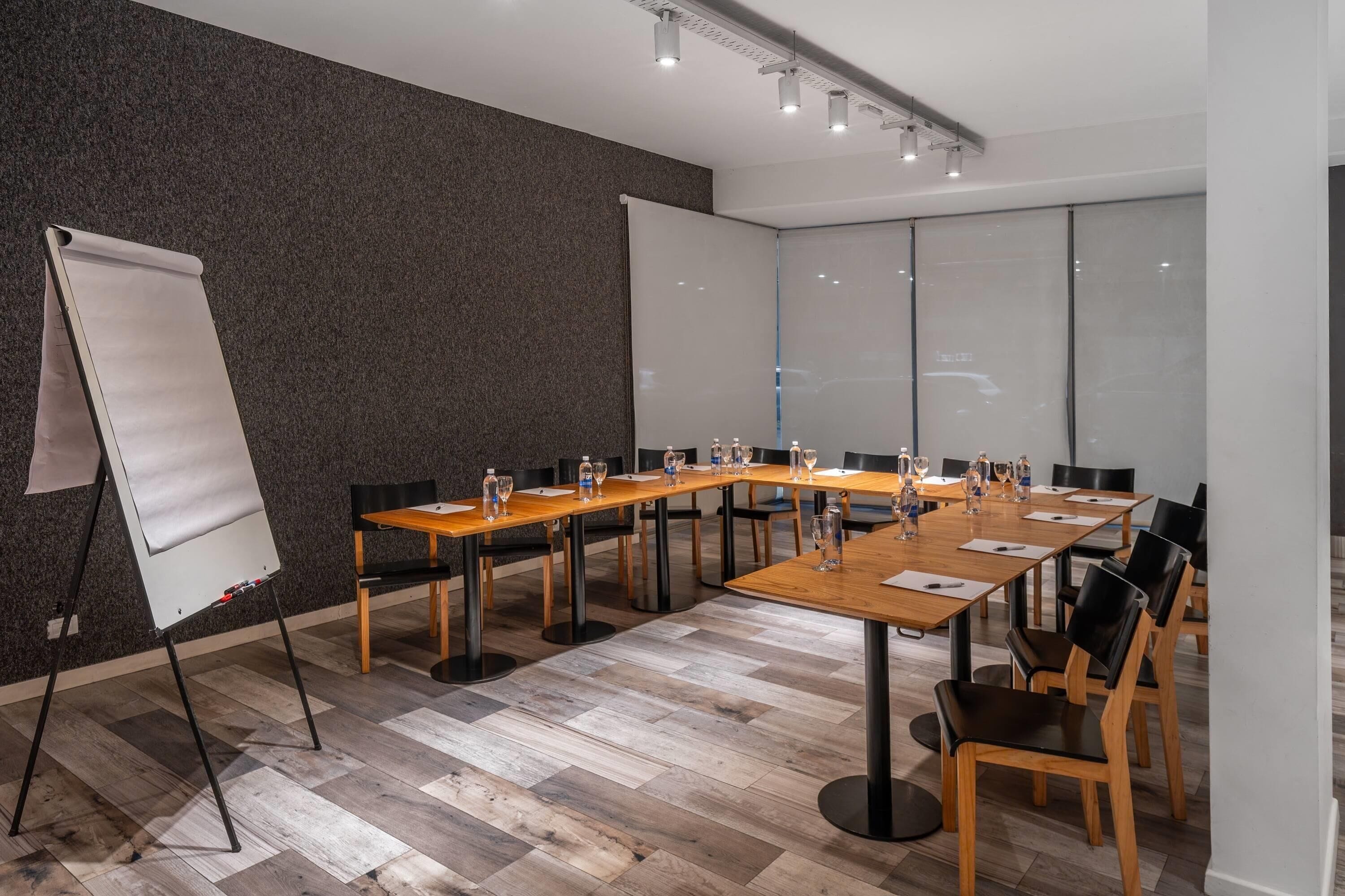 Une salle de conférence équipée d’un tableau blanc, de longues tables et de chaises.