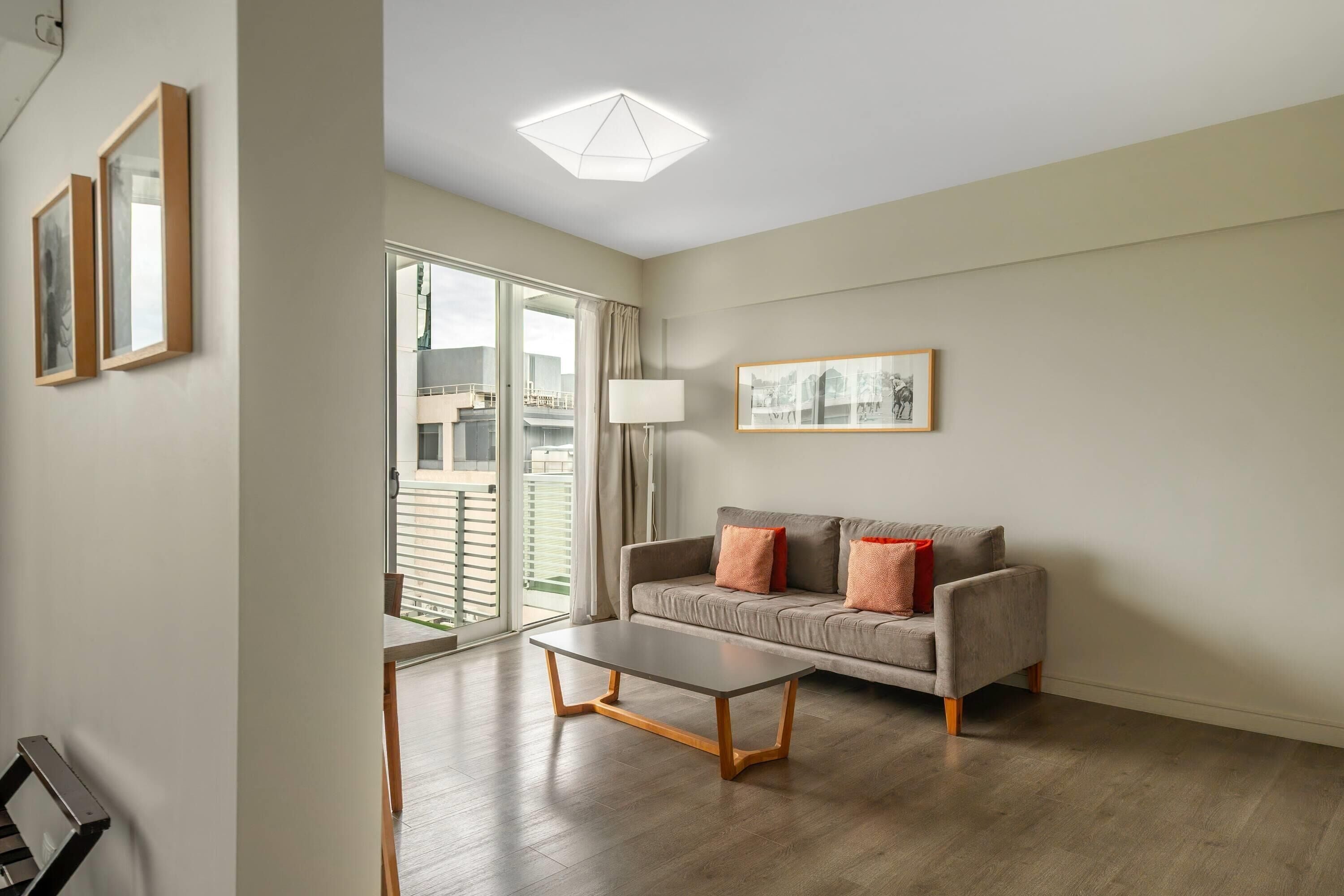Una sala de estar moderna con un sofá, una mesa de centro y un ventanal que ofrece vistas al exterior.