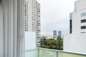 A high-rise building with a view of other buildings and trees in the background.