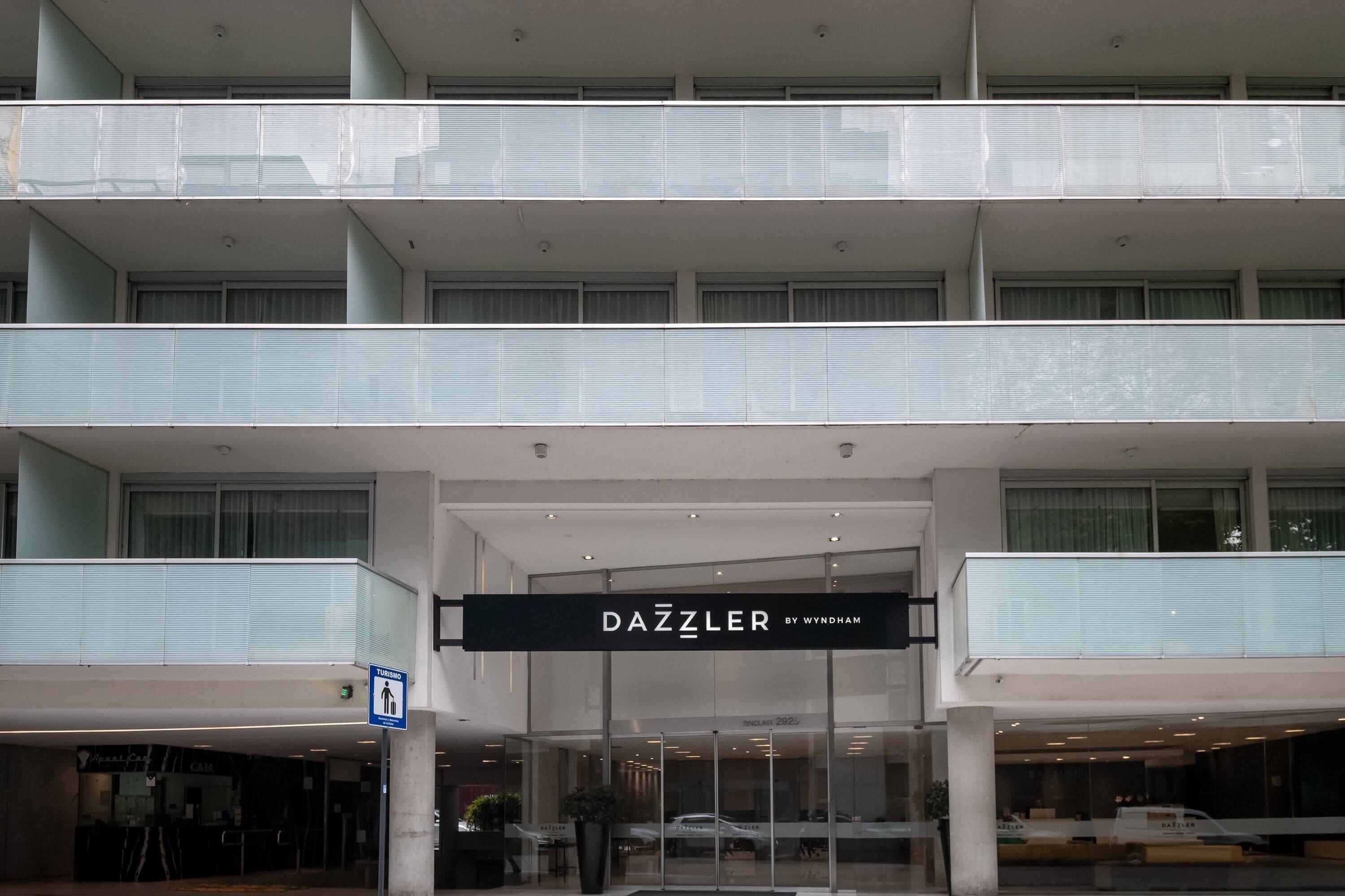 Ein mehrstöckiges Gebäude mit einem gut sichtbaren 'DAZZLER BY WYNDHAM' Schild am Eingang.