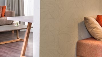 Una sala de estar moderna con un sofá, una mesa de centro y un papel tapiz estampado.
