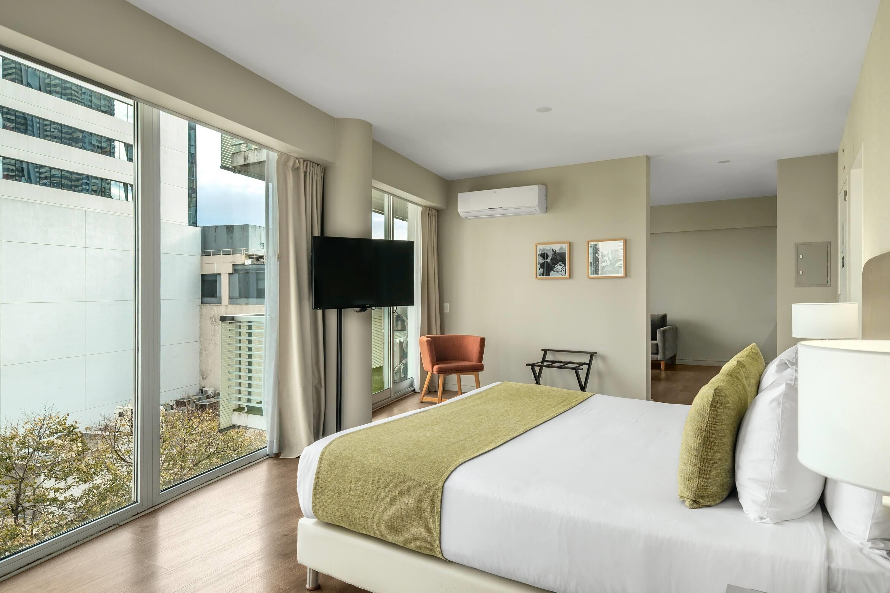 Une chambre d’hôtel avec un grand lit, une télévision, une chaise et un bureau.