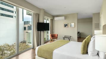 Une chambre d’hôtel avec un grand lit, une télévision, une chaise et un bureau.